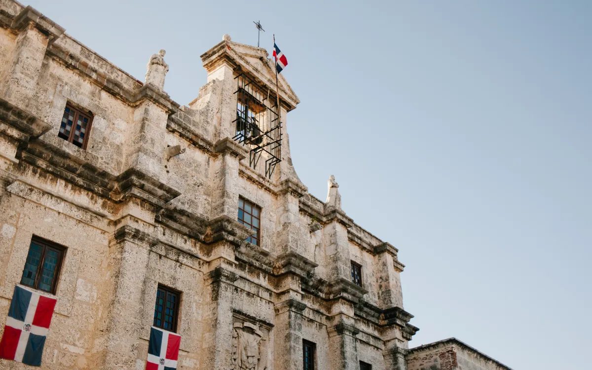 Edificio colonial de piedra con banderas dominicanas en la Zona Colonial de Santo Domingo